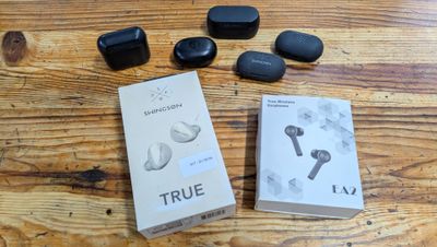 a box of true wireless earbuds and a box of true wireless earbuds on a wooden table