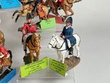 many figurines of people riding horses on display