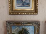 two paintings hanging on the wall in a room