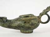 an image of a small bronze object with a bird on it ' s head