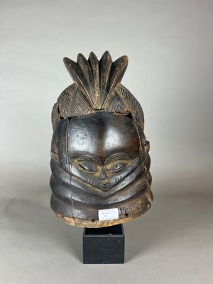 gros plan d'un masque en bois sur un support noir