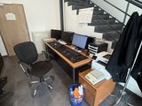 un bureau avec un ordinateur et une chaise dans une pièce