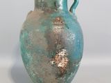 a blue vase that is sitting on a white surface