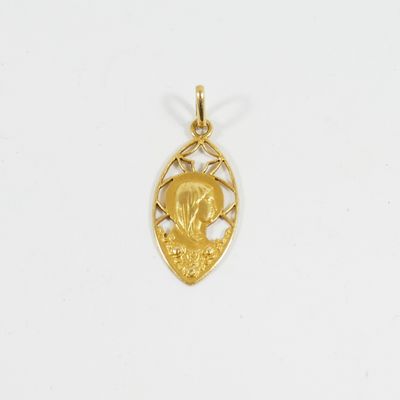 un pendentif plaqué or représentant une femme dans un arbre