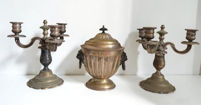 three brass candelabs sitting on a white table