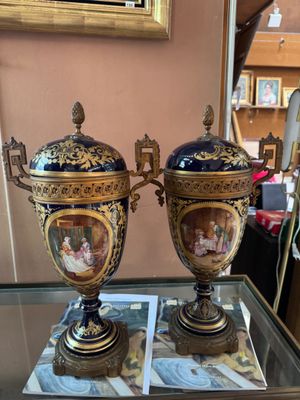 two vases are sitting on a glass table in front of a mirror