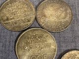 four different coins sitting on top of each other on a blue cloth