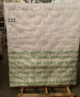 un gros plan d'un matelas posé sur une palette dans un entrepôt