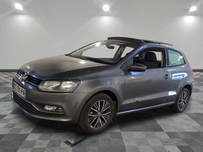 La Volkswagen Polo grise est garée sur un sol en carrelage à damier.