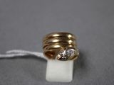 gros plan d'une bague en or surmontée d'un diamant