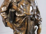 bronze statue of a man with a book and a hat