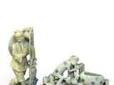 two ivory figurines of a man and a woman on a boat