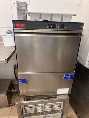 a stainless steel dishwasher sitting on top of a metal rack