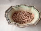 a bowl filled with brown beans sitting on a table