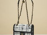 a black and white bag with a chain hanging from it