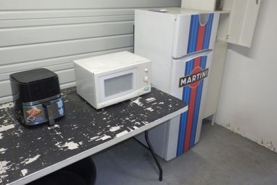 deux micro-ondes posés sur une table à côté d'un réfrigérateur
