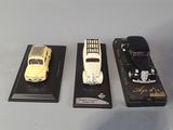 three different model cars on display on a table