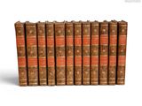 six vieux livres alignés sur une surface blanche
