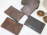 four old wallets sitting on a table next to a bottle of soap