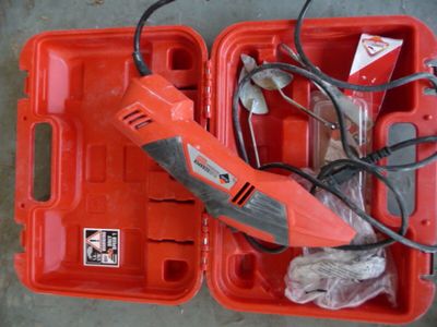 une boîte rouge contenant une perceuse à fil et un outil