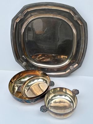 deux plats en argent posés l'un à côté de l'autre sur une table