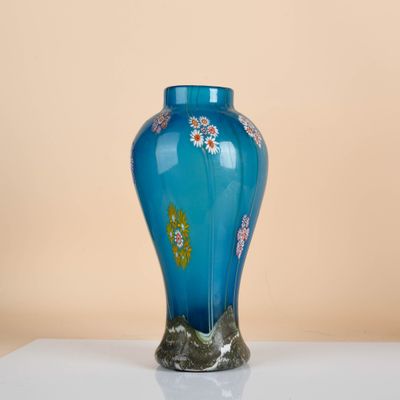 a blue vase sitting on top of a white table