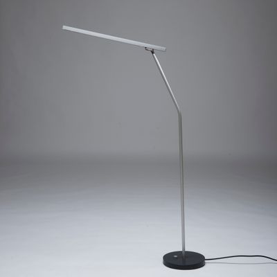 un gros plan d'une lampe posée sur une surface blanche, avec un pied noir