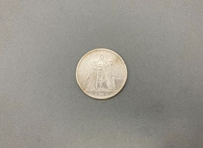 un gros plan d'une pièce d'argent posée sur une surface grise