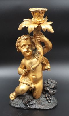an image of a gold statue of a child holding a flower