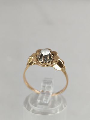 a close up of a gold ring with a diamond on it