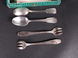four spoons and two spoon spoons in a green box