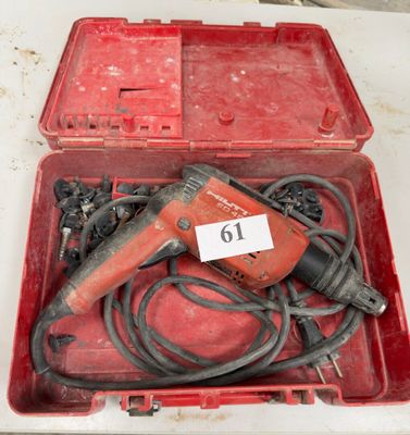 une boîte rouge contenant une perceuse et d'autres outils