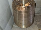 a coil of copper wire on the ground next to a pair of scissors
