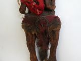 une sculpture en bois représentant une femme assise sur une chaise