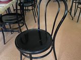 tables and chairs in a restaurant with a dog sitting in the middle of the room