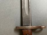 a close up of a knife on a stand on a wall