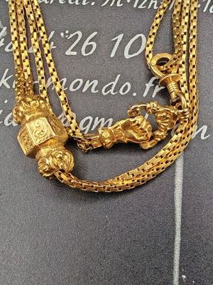 collier plaqué or orné d'un lion et d'une tête de lion, monté sur une chaîne