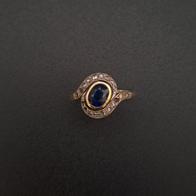 a close up of a gold ring with a blue stone