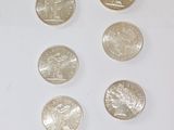 several quarters of silver coins are arranged in a row on a white surface