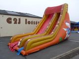 un grand toboggan aquatique gonflable installé sur un parking
