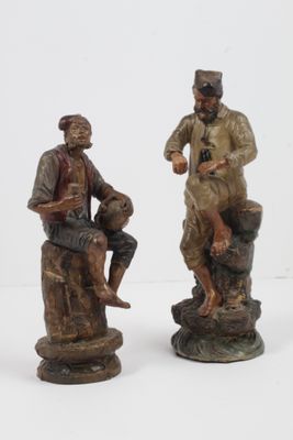 deux figurines représentant un homme et une femme assis sur un rocher