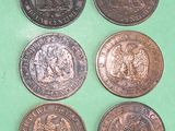 six different british coins sitting on top of a green surface