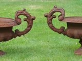 two metal urns that are sitting in the grass