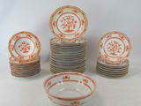 many plates and bowls with orange designs on them