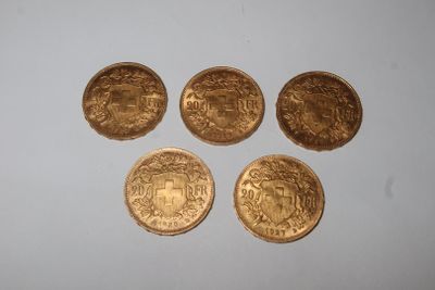 four gold coins sitting on top of each other on a white surface
