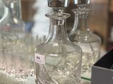 a glass shelf with a lot of glass bottles on it