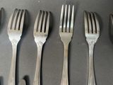 six forks that are sitting next to each other on a table