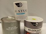two tins of paint sitting on a table next to a can of paint