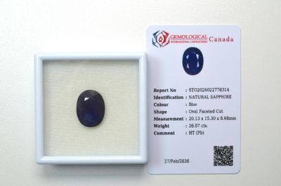 un saphir bleu dans un écrin blanc, à côté d'une carte