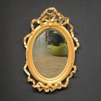 a mirror that is hanging on the wall next to a chair